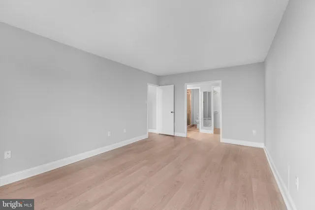 a view of an empty room with wooden floor