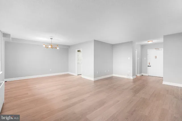 a view of an empty room with wooden floor