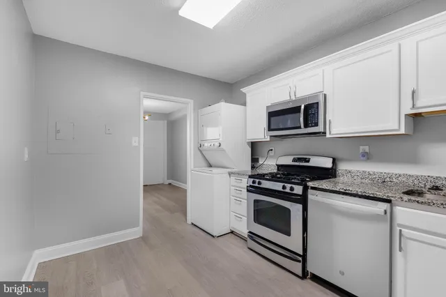 a kitchen with granite countertop cabinets stainless steel appliances and wooden floor