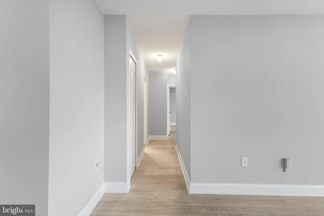 a view of a hallway with wooden floor