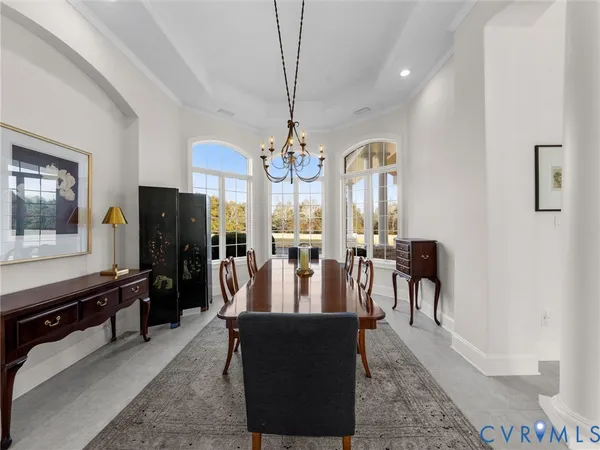 a view of a dining room with furniture a chandelier and wooden floor