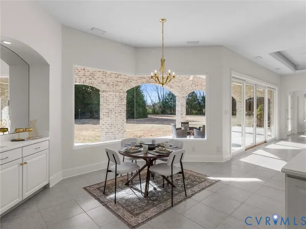 a view of a dining room and livingroom with furniture wooden floor a chandelier