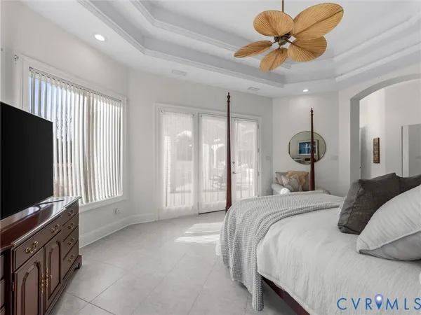 a bedroom with a large bed and a flat tv screen on dresser