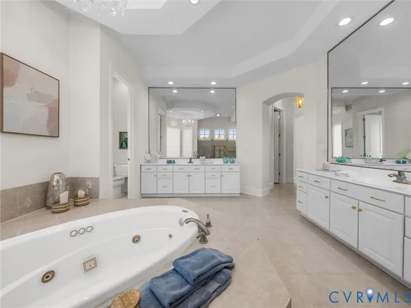 a large bathroom with a tub a double vanity sink and mirror