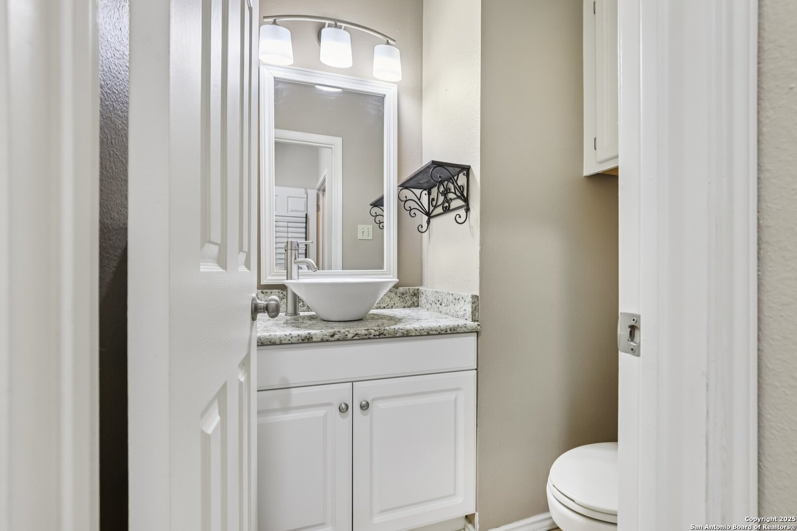 5834 Spring Crossing San Antonio, TX 78247 - Photo 16 of 29 a bathroom with a granite countertop sink vanity mirror and toilet