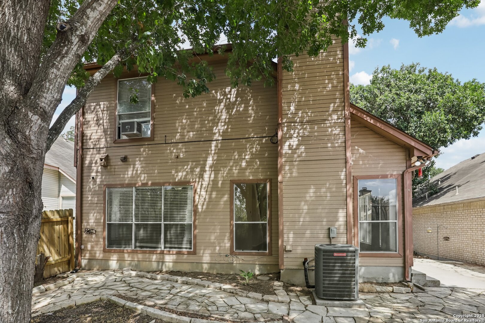 5834 Spring Crossing San Antonio, TX 78247 - Photo 23 of 29 a view of a brick house with large windows and a tree