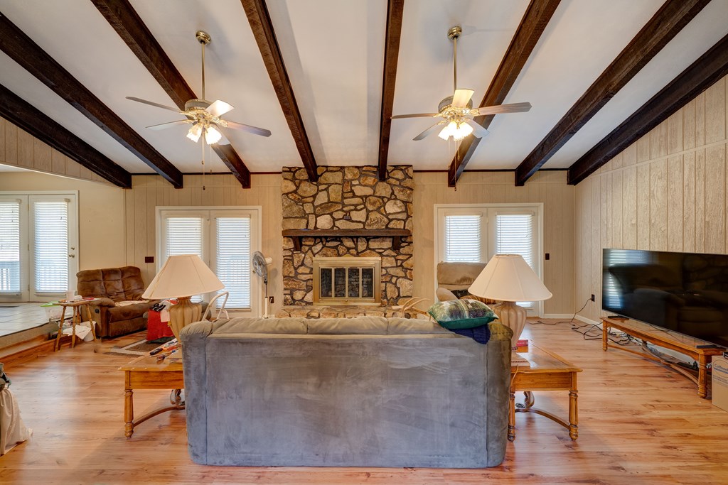 1676 Shoal Creek Road Dawsonville, GA 30534 - Photo 16 of 40 a living room with furniture a flat screen tv and a fireplace