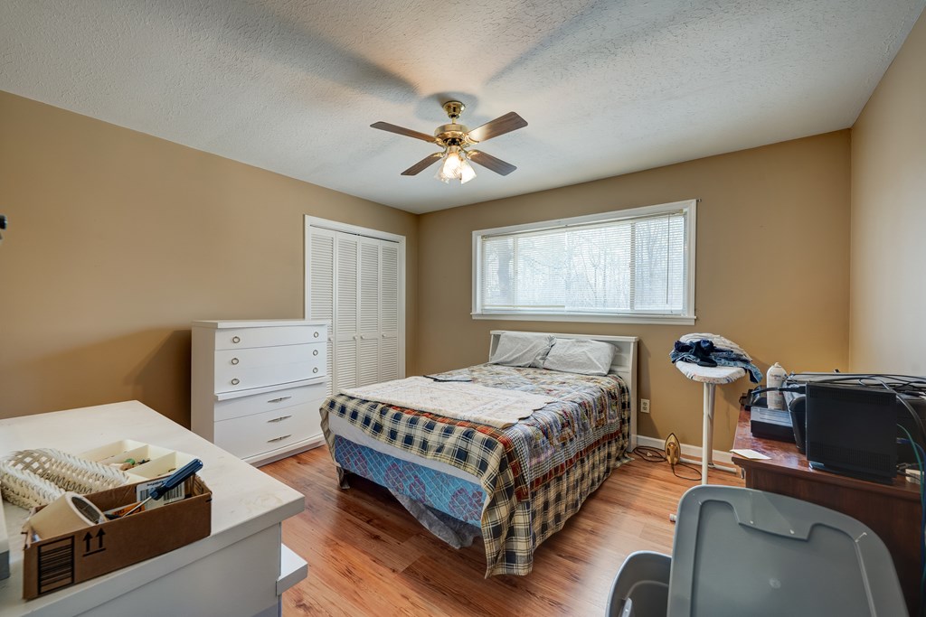 1676 Shoal Creek Road Dawsonville, GA 30534 - Photo 23 of 40 a bedroom with a bed and a chandelier