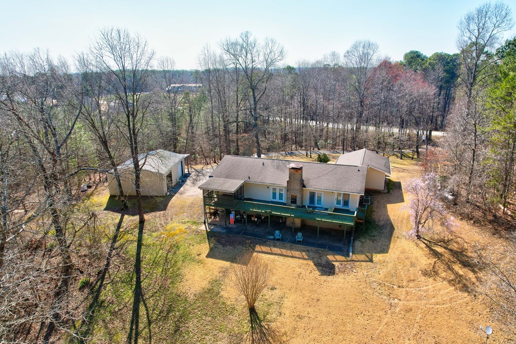 1676 Shoal Creek Road Dawsonville, GA 30534 - Photo 6 of 40 a wooden bench sitting in a backyard of a house