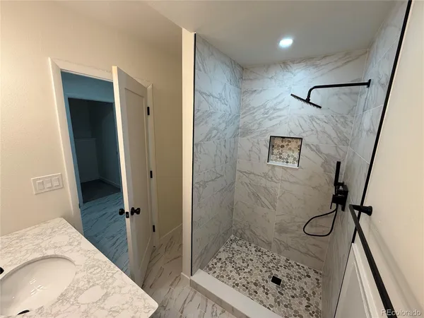 a bathroom with a granite countertop sink a toilet and shower