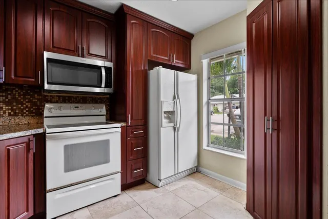 a kitchen with granite countertop wooden cabinets and stainless steel appliances