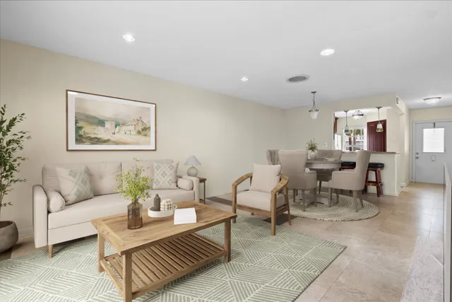 a living room with furniture and a dining table with kitchen view