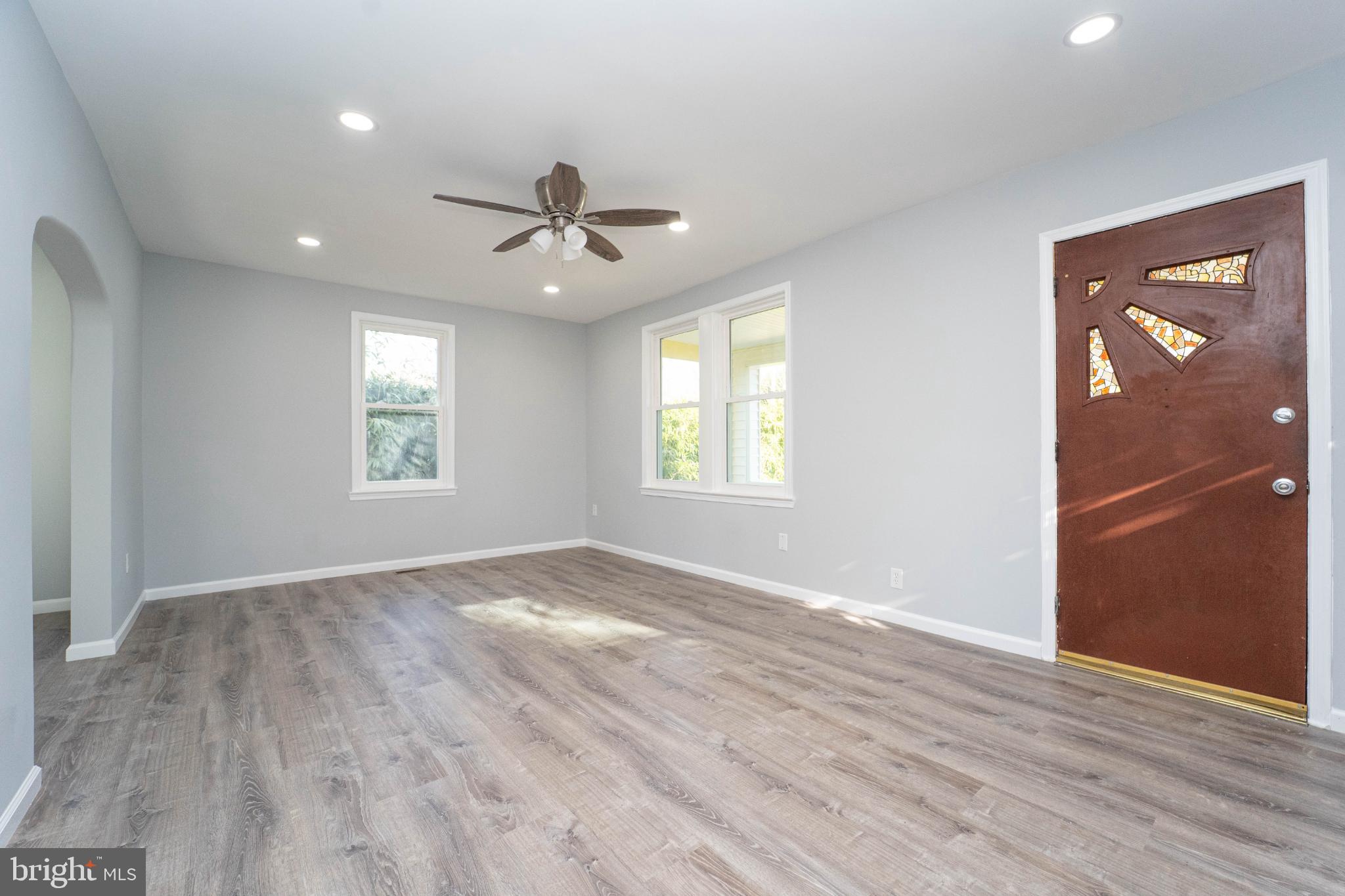 5312 Catalpha Road Baltimore, MD 21214 - Photo 7 of 59 a view of an empty room with a window and wooden floor