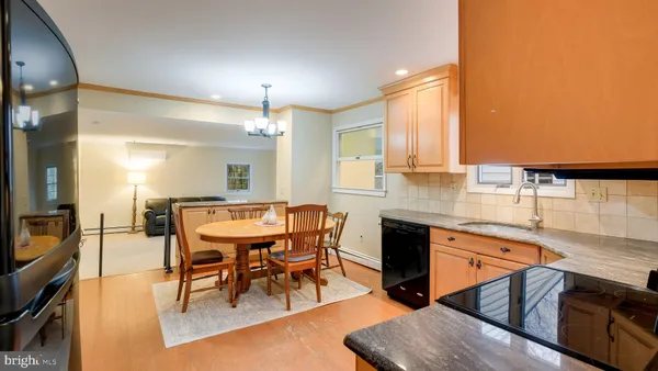 a kitchen with stainless steel appliances granite countertop table chairs sink and cabinets