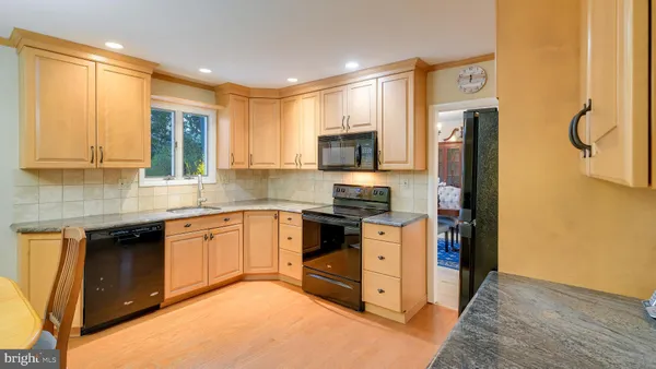 a kitchen with stainless steel appliances granite countertop a stove a sink a refrigerator and a microwave