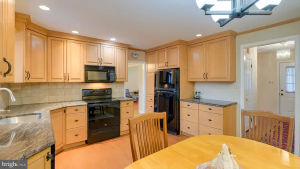 a open kitchen with stainless steel appliances granite countertop a stove top oven a sink dishwasher and a microwave oven with cabinets