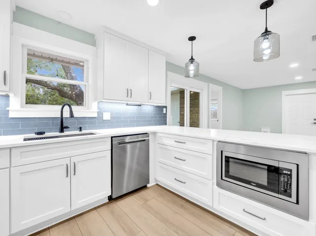 a bathroom with a granite countertop sink a toilet a mirror a bathtub and shower