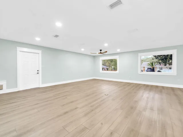 a front view of a house with a garden and trees