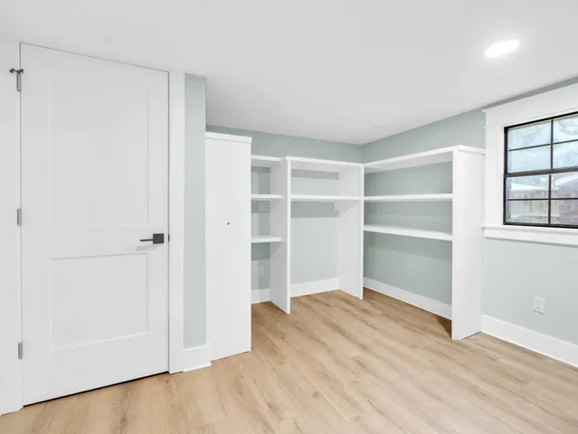 front view of a house with a large window and potted plants