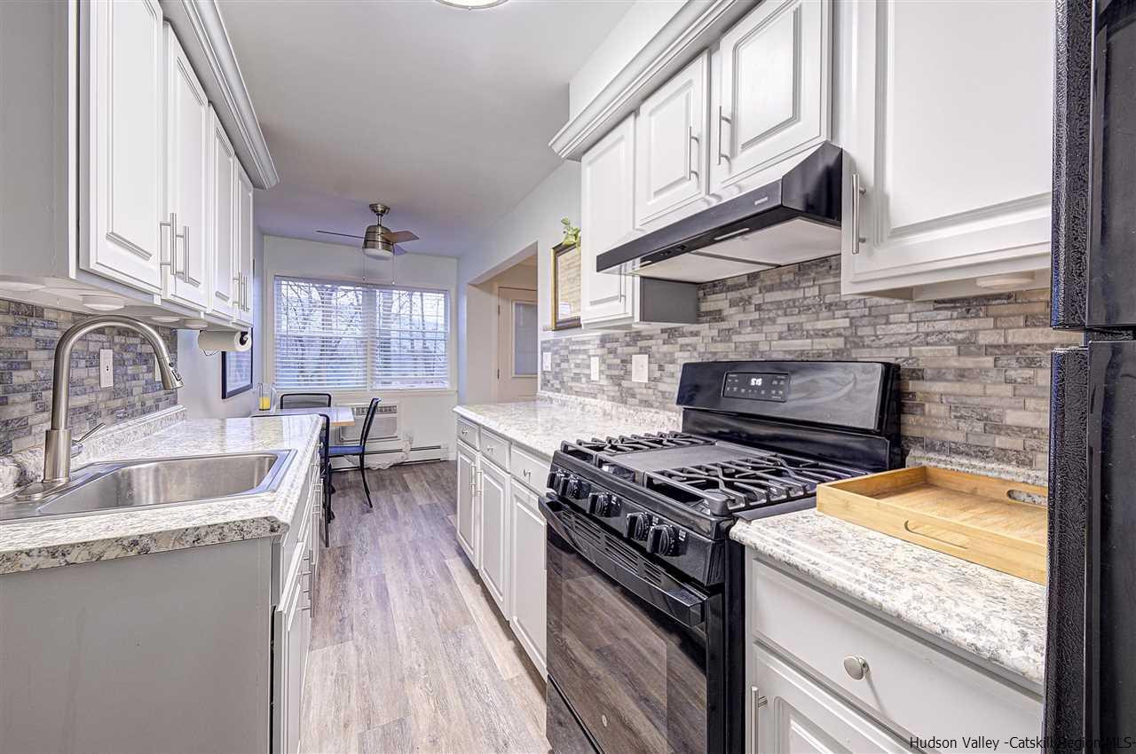 2 Colonial Road, Unit 146 Beacon, NY 12508 - Photo 11 of 13 a kitchen with granite countertop a stove a sink and a wooden cabinets