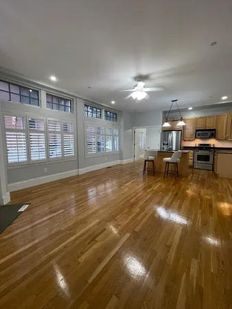 a view of a living room and kitchen with furniture wooden floor and chandelier
