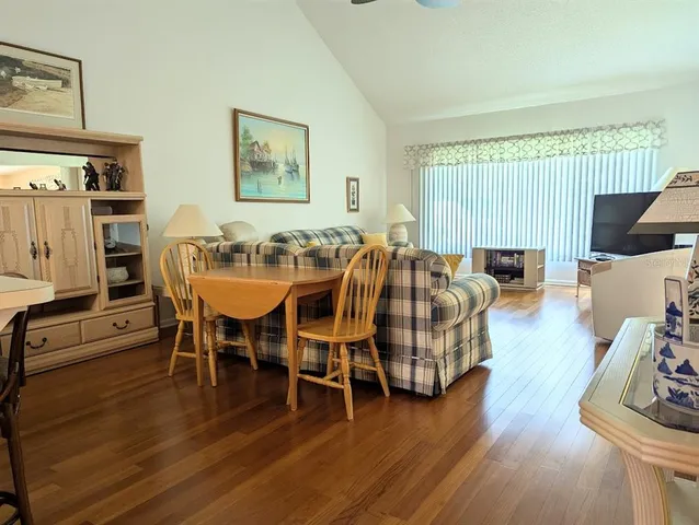 a dining room with furniture wooden floor a rug and a painting