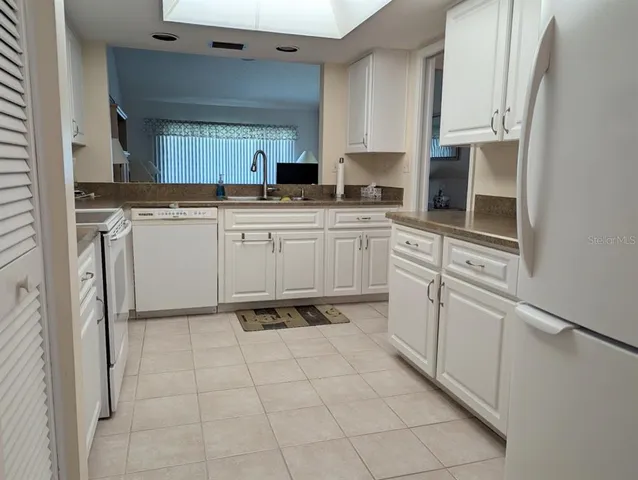 a kitchen with white cabinets appliances and a sink