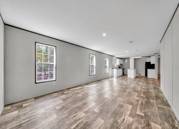 a view of empty room with wooden floor and window