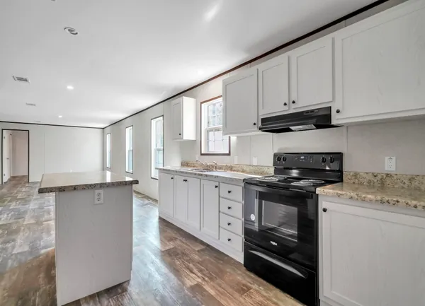 a kitchen with granite countertop a sink stainless steel appliances and cabinets