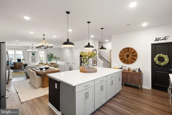 a kitchen with a sink stove and wooden floor