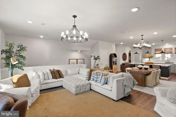 a living room with furniture a chandelier and a flat screen tv