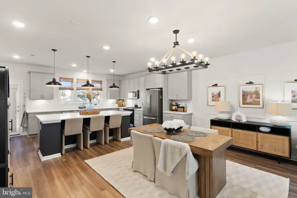 a living room with furniture a chandelier and a dining table