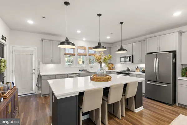 a kitchen with a dining table chairs sink and wooden floor