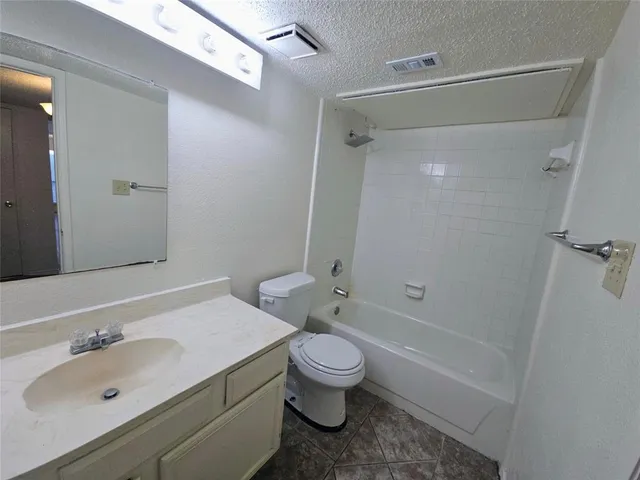 an empty room with wooden floor ceiling fan and windows