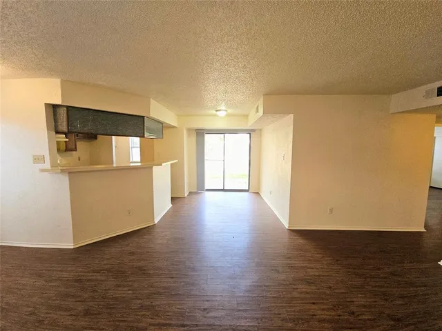 a view of a kitchen with wooden floor and a refrigerator