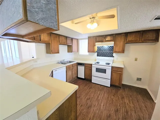 a view of a kitchen counter space wooden floor electronic appliances and windows