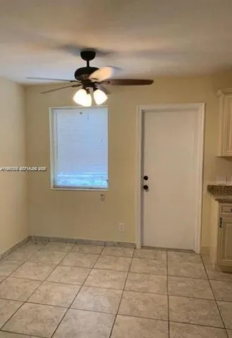 a view of a livingroom with a chandelier fan and windows