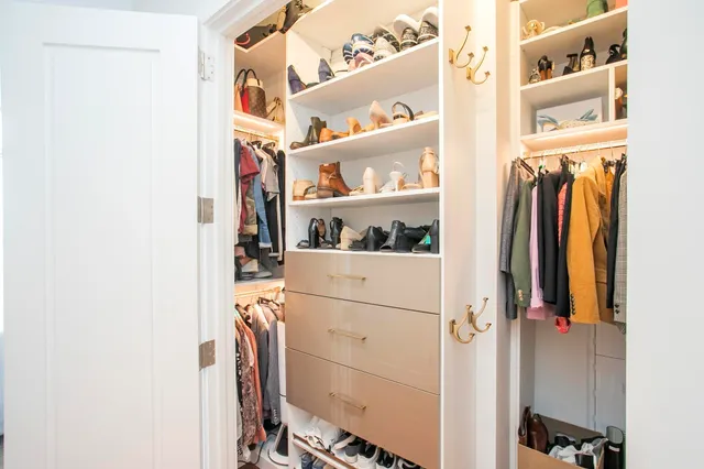 a view of walk in closet with clothes and shoes