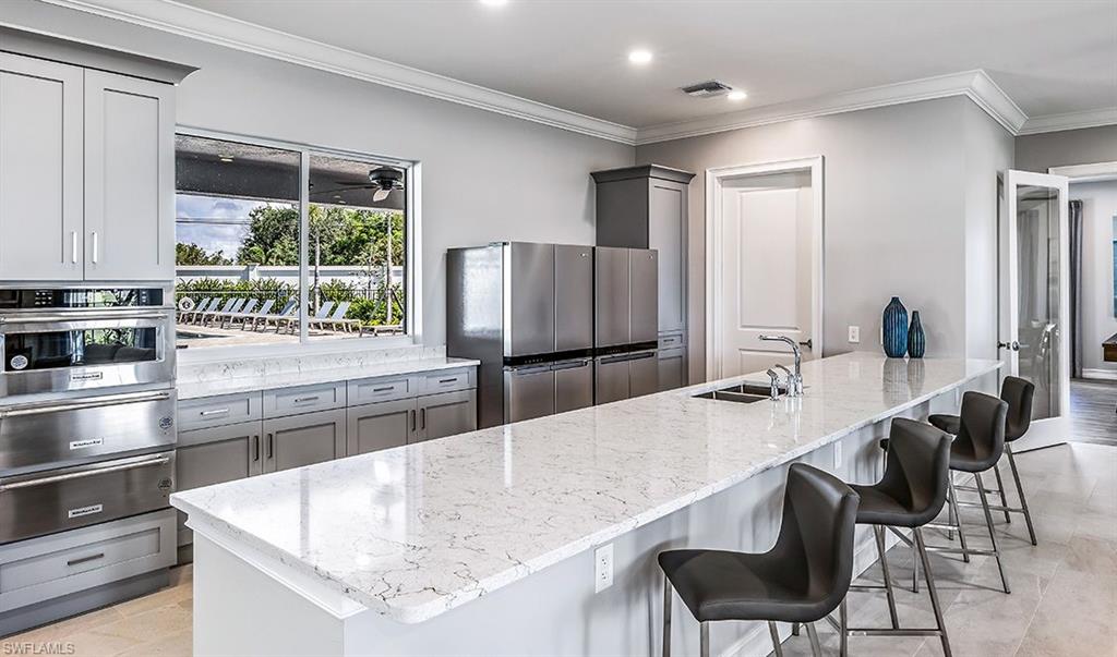 846 Enbrook Loop Naples, FL 34114 - Photo 30 of 45 a kitchen with stainless steel appliances granite countertop a sink and a refrigerator