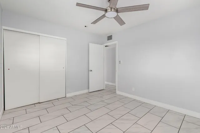 an empty room with a window and a fan