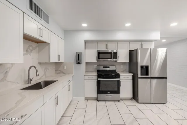 a kitchen with stainless steel appliances a refrigerator sink and microwave