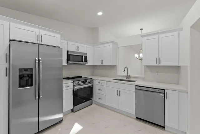 a kitchen with a sink stainless steel appliances and cabinets