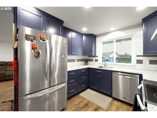 a kitchen with stainless steel appliances granite countertop a refrigerator a sink and a stove