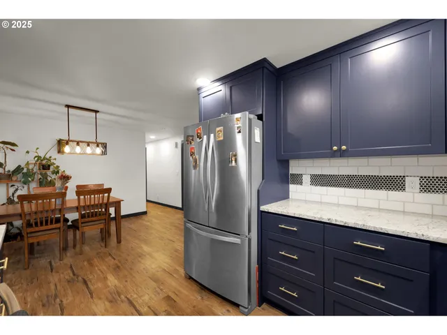 a kitchen with stainless steel appliances granite countertop a refrigerator and a sink