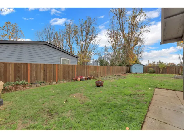 a view of backyard with wooden fence