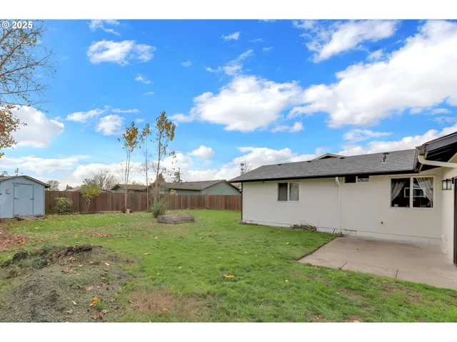 a backyard of a house with table and chairs