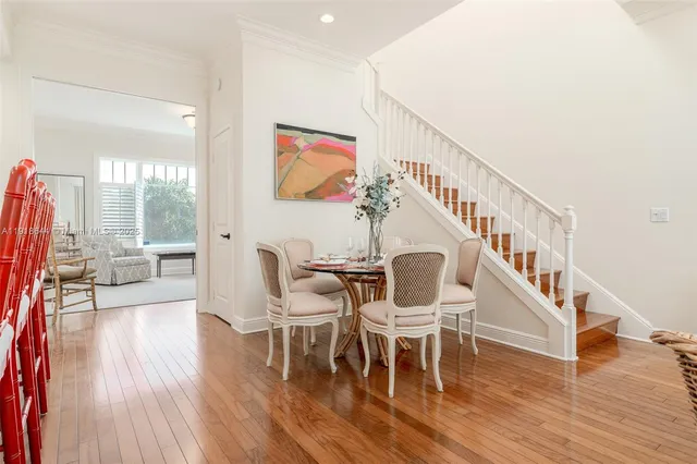 a dining room with furniture a floor to ceiling window and wooden floor