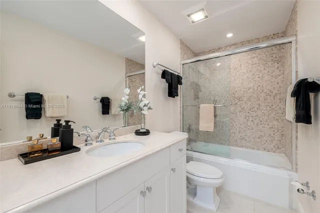 a bathroom with a sink a toilet a mirror a bathtub and shower