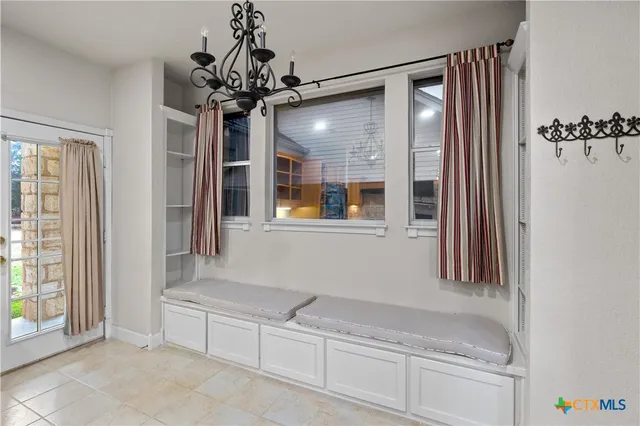 an empty room with chandelier fan and closet area