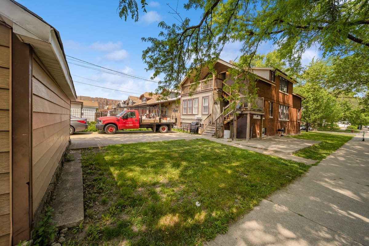 4703 West Parker Avenue Chicago, IL 60639 - Photo 24 of 27 a front view of a building with a yard